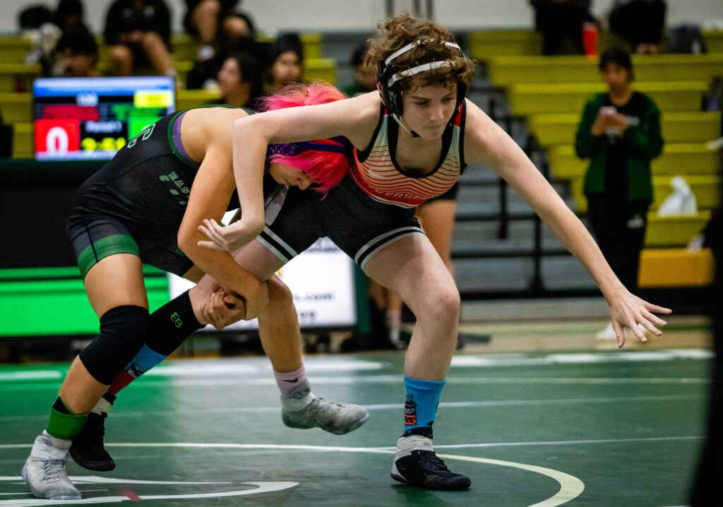 Mollie Jimenez, Freshman, East Los Angeles College vs Amber Chatterton, Freshman, Bakersfield College. 109-pound weight class. Here Jimenez has a grip on Chatterton's leg as she lunges toward the mat.