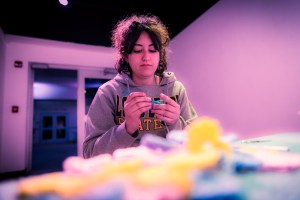 Claudia Solorzano crocheting in her exhibition in the Long Beach State University's Merlino Gallery